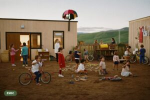 Small child care centre on the Alberta prairie at golden hour with children's bikes by the fence